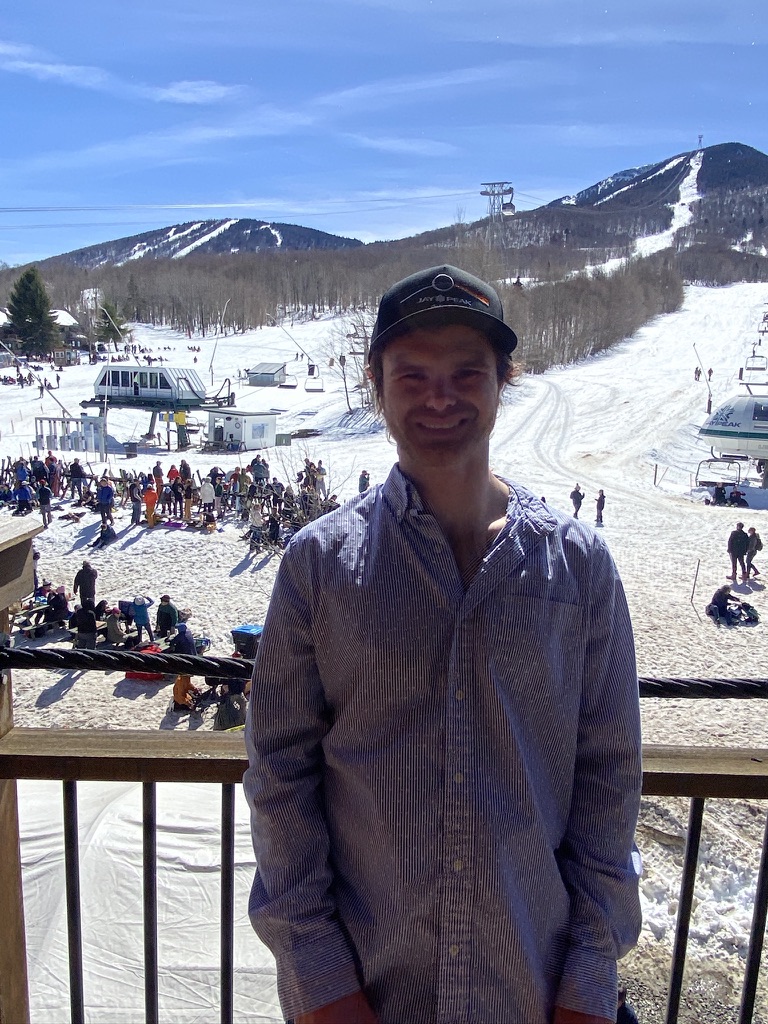 Me on a balcony with the slopes of Jay Peak ski Resort 